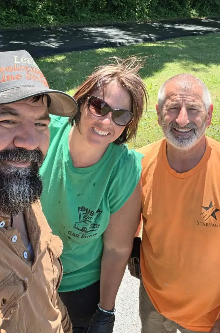Randy Leek's crew smiling on a job site next to a freshly sealed drive