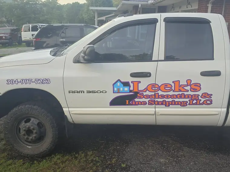 White Ram pickup lettered Leek's Sealcoating and Line Striping LLC