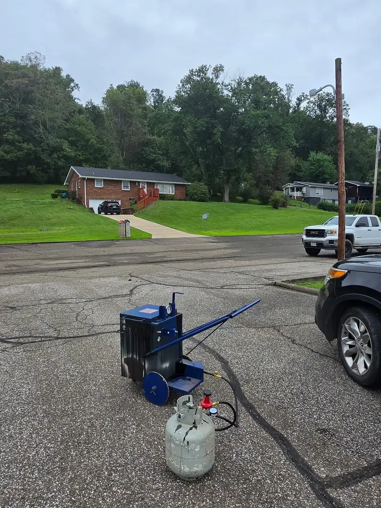 Hot crack filling melter set up on a cracked asphalt driveway in the Ohio Valley