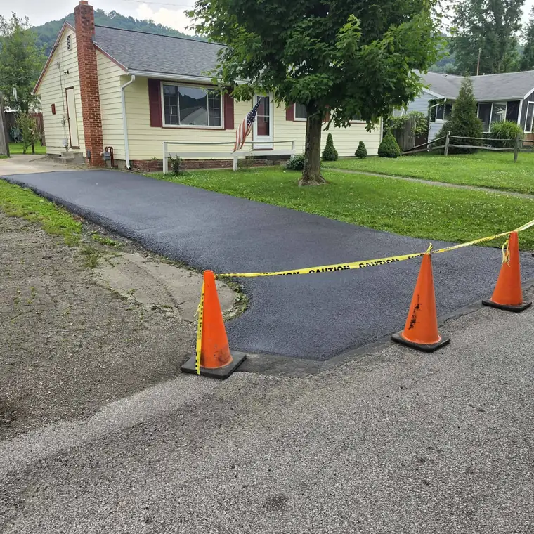 Freshly sealed home driveway blocked off with orange cones and caution tape in the Ohio Valley