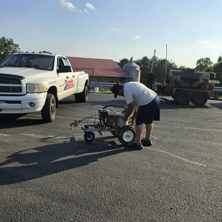 Walk-behind line striping machine painting parking lot lines, Wetzel County WV